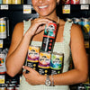Woman holding multiple cans of Wild Tide Hard Ginger Beer in a store setting